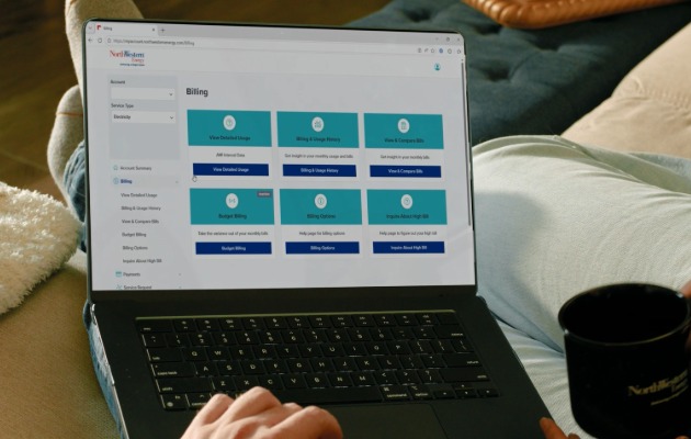 Customer viewing the My Energy Account dashboard on a laptop computer, displaying billing and energy management tools, including detailed energy usage, budget billing and usage alerts.